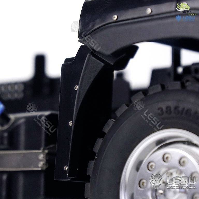 Zbliżenie modelu samochodu ciężarowego, przedstawiające fragment koła i tylną część błotnika.