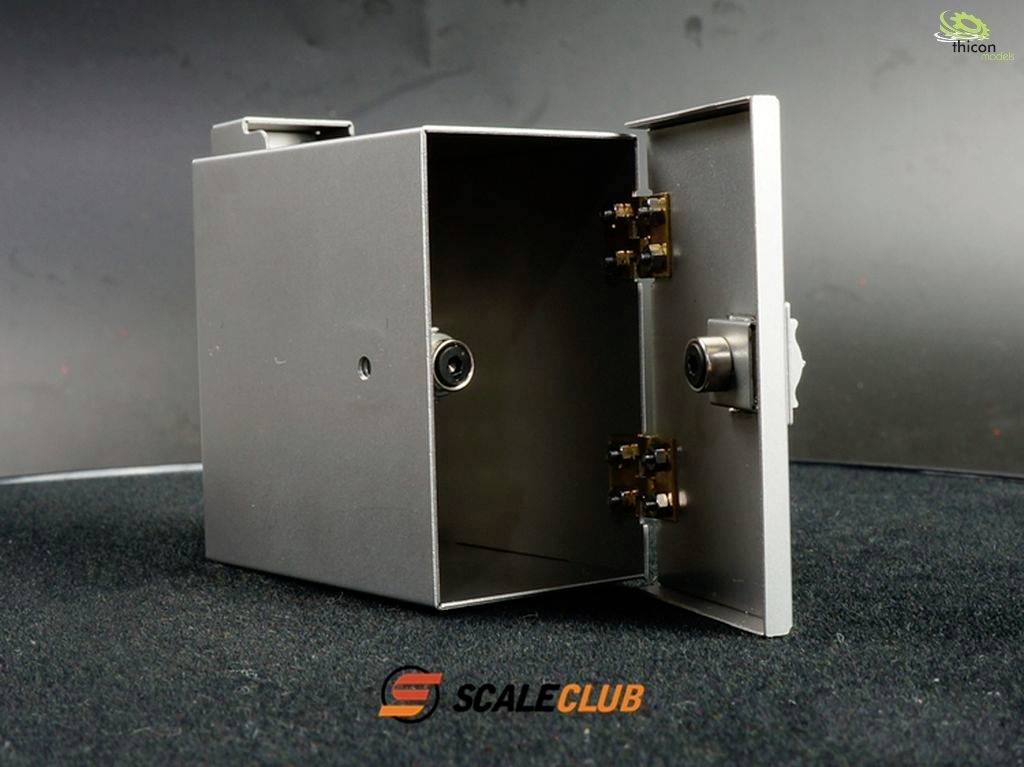 Metalowa skrzynka z otwartymi drzwiczkami, ukazująca zawiasy i mechanizm zamykający. Na dole widoczne logo marki 'Scale Club'.