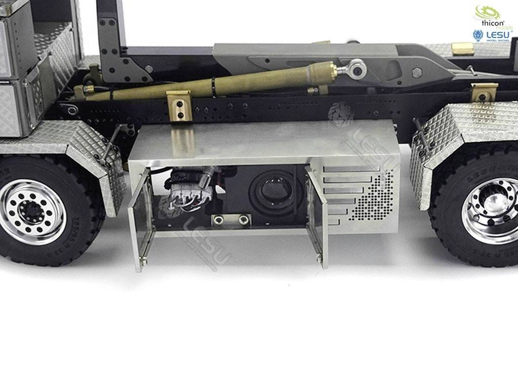 Model ciężarówki siodłowej z widocznym podwoziem. Otwarte wnętrze prezentuje komponenty elektryczne. Metaliczne i czarne detale.