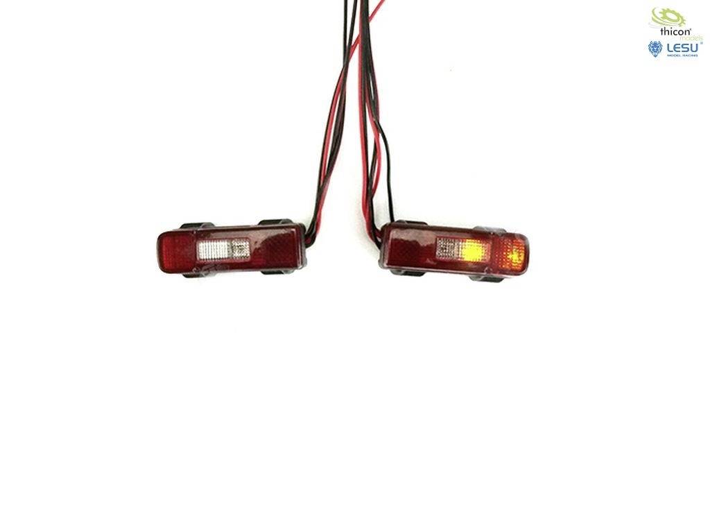 Dwie małe czerwone lampy tylne z kablami na białym tle, jedna świeci się na pomarańczowo. Logotypy marek w górnym prawym rogu.