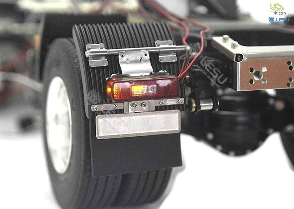 Zbliżenie koła modelowego samochodu ciężarowego z tylnym światłem i kablami przymocowanymi do zawieszenia.