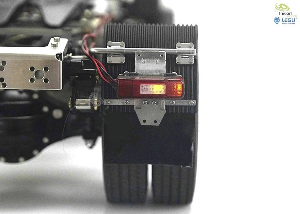 Zbliżenie systemu tylnych świateł pojazdu z dwoma kołami. Widoczne są przewody elektryczne. Oznaczenia w prawym górnym rogu przedstawiają 'Thicon' i 'Lesu'.