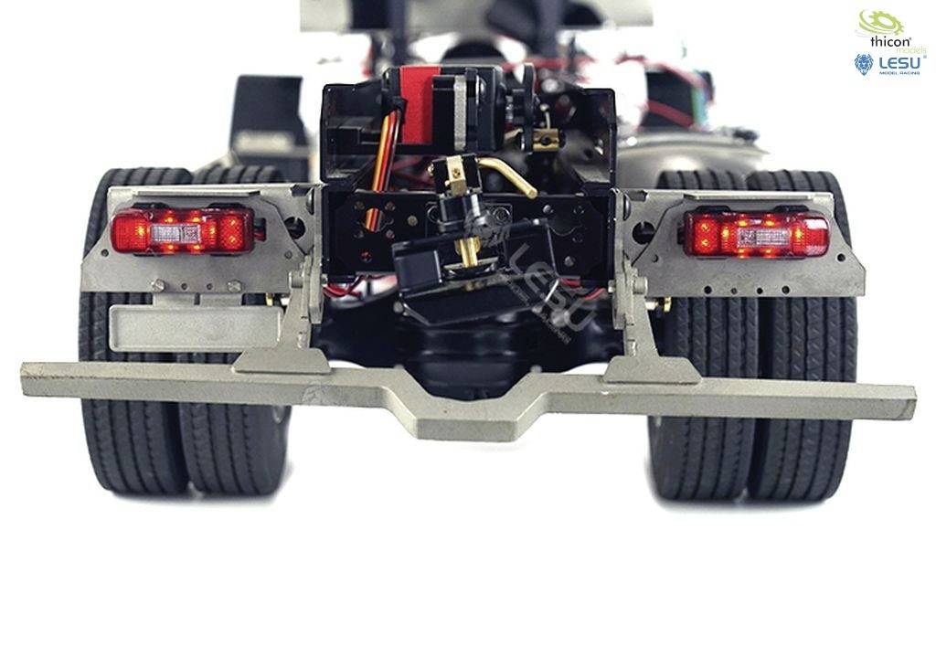 Zbliżenie podwozia ciężarówki z widoczną elektroniką i przewodami. W lewym górnym rogu logo producentów 'thicon' i 'LESU'.