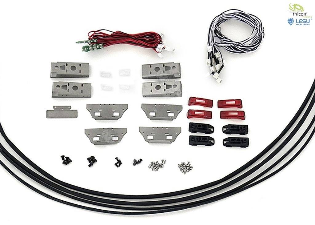 Różne elektroniczne i mechaniczne elementy, w tym przewody, mocowania metalowe i śruby, na białym tle.