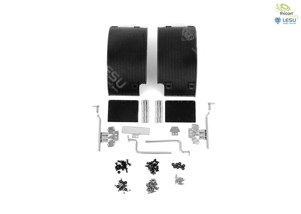 Zestaw montażowy z dwoma czarnymi osłonami kół, elementami metalowymi i śrubami mocującymi, sfotografowany na białym tle.