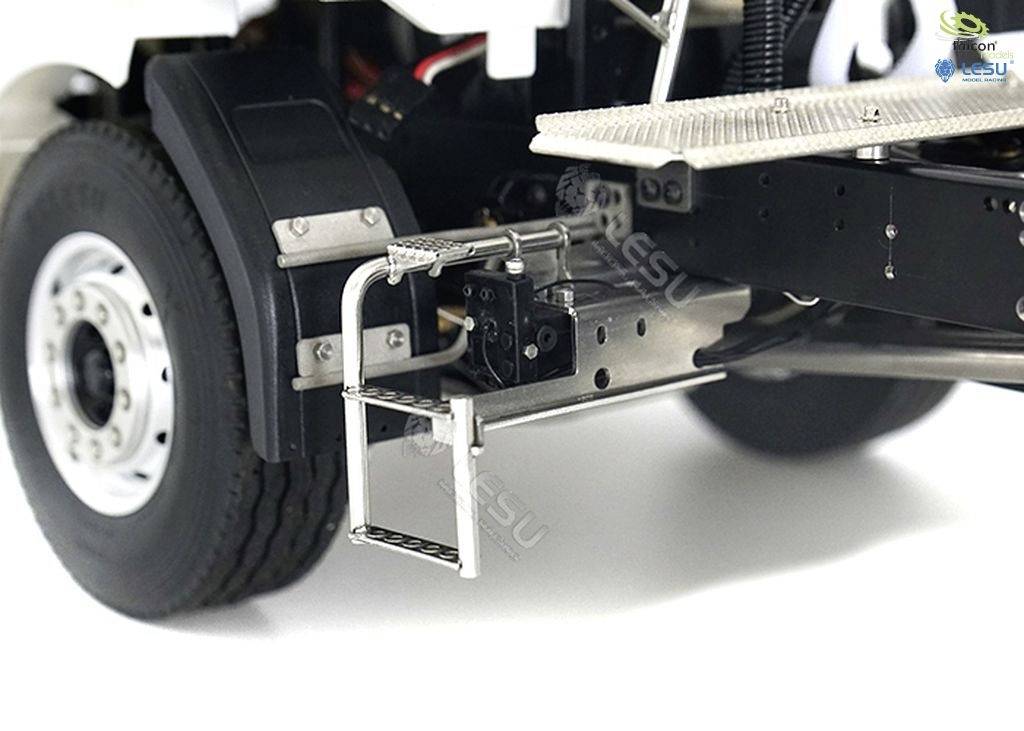 Zbliżenie modelu ciężarówki, prezentujące szczegół bocznego stopnia i zawieszenia pojazdu z kołem.