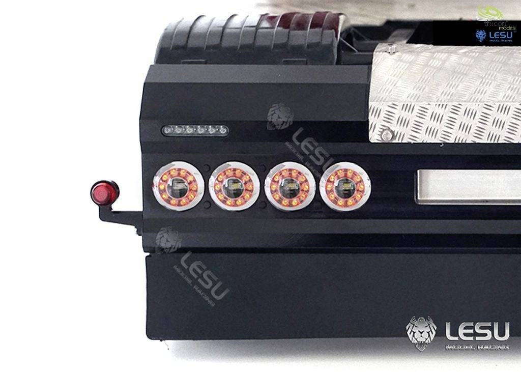 Niekompletny model ciężkiego pojazdu z dokładnymi atrapami kół, czarna podstawa, częściowo zmontowane struktury.