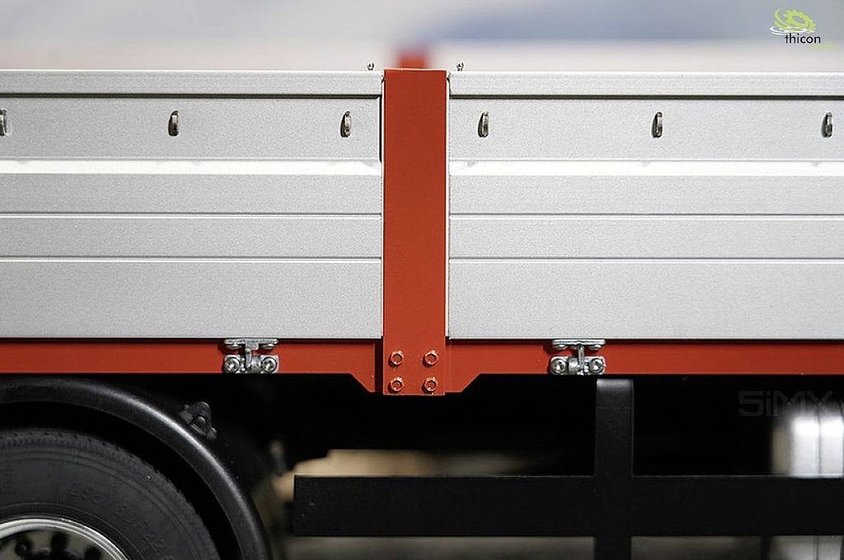 Srebrno-szary i czerwony wisiorek z czarnym podwoziem, z naciskiem na połączenia i szczegóły strukturalne. Czysty, bezchmurny niebo w tle.