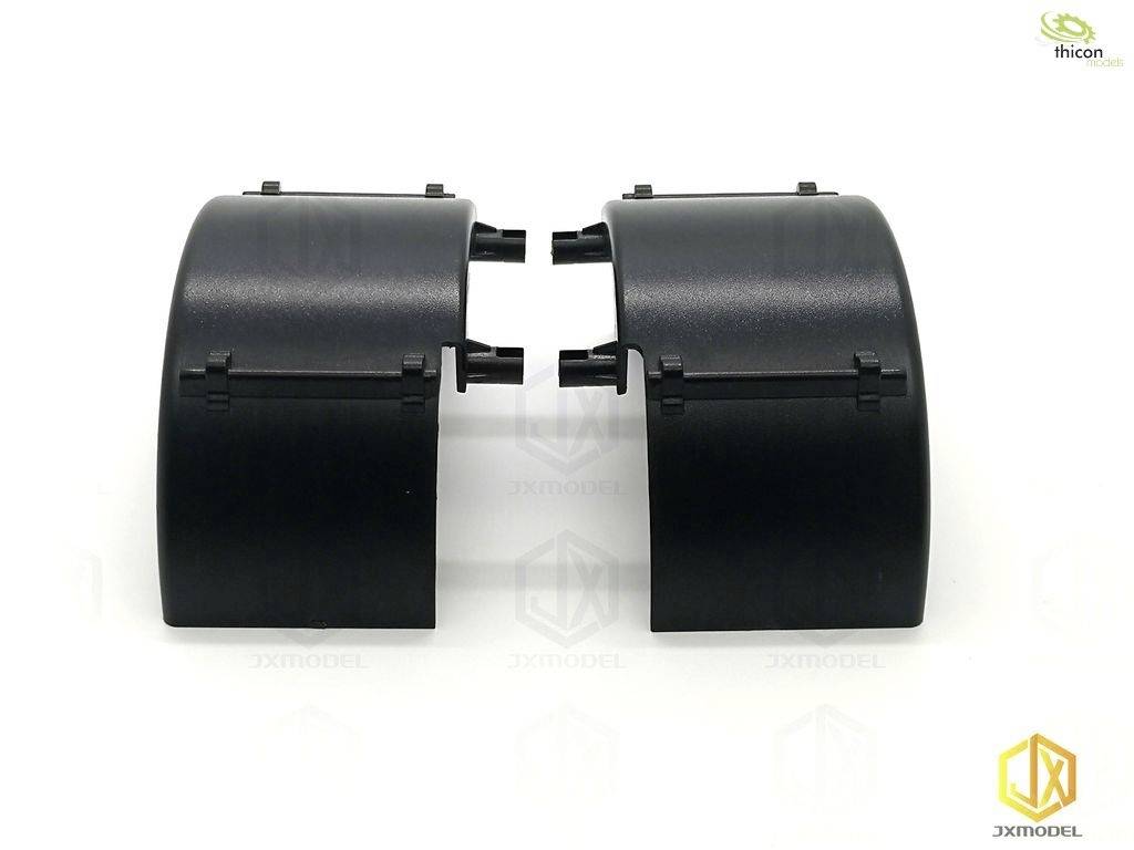 Dwie czarne, wygięte plastikowe części leżą obok siebie na białym tle, prawdopodobnie elementy jakiegoś modelu lub produktu.