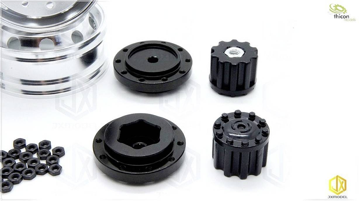 Różne czarne i srebrne elementy metalowe, przypuszczalnie do modelarstwa lub budowy maszyn, ułożone na białym tle.