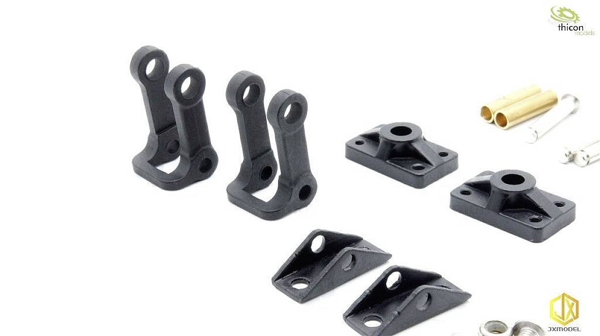 Małe czarne elementy z tworzywa sztucznego i metalowe akcesoria do modelarstwa, ułożone na białym tle.