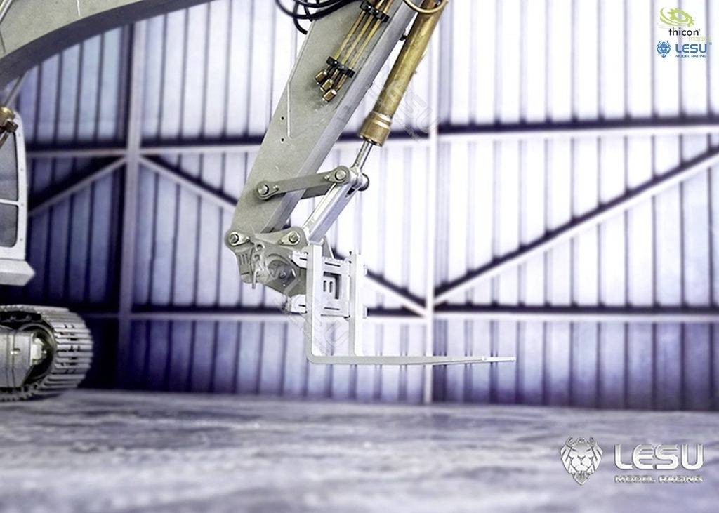 Hydrauliczny wysięgnik dużej maszyny budowlanej znajduje się w magazynie o metalowych ścianach. W górnym rogu widoczne są logo.