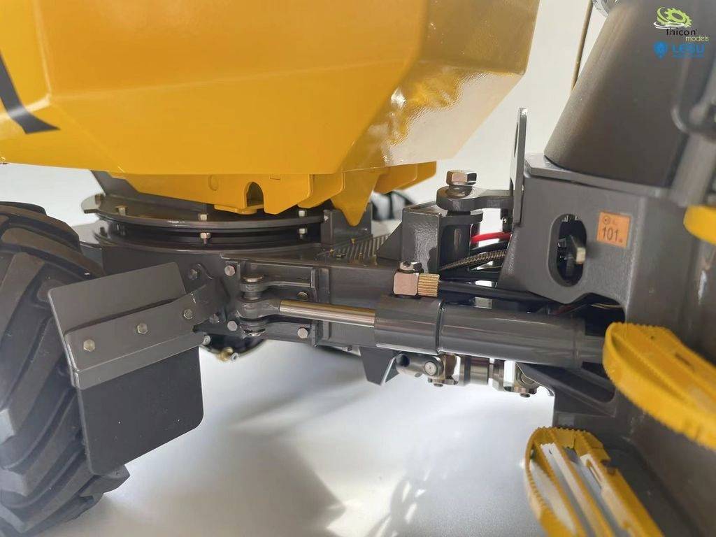 Zbliżenie żółtej zabawkowej wywrotki, ukazujące szczegółowe elementy mechaniczne i połączenia.