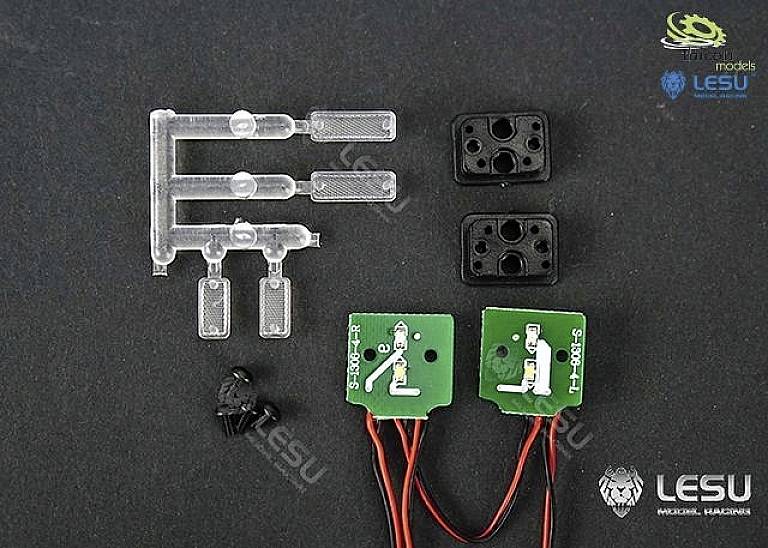 Elektroniczne elementy na czarnym tle: zielone płytki drukowane z kablami, przezroczyste elementy plastikowe oraz czarne złącza.