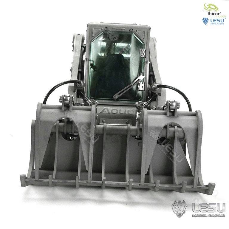 Model ładowarki czołowej z zamkniętą kabiną i łyżką chwytakową, przedstawiony w neutralnym kolorze.