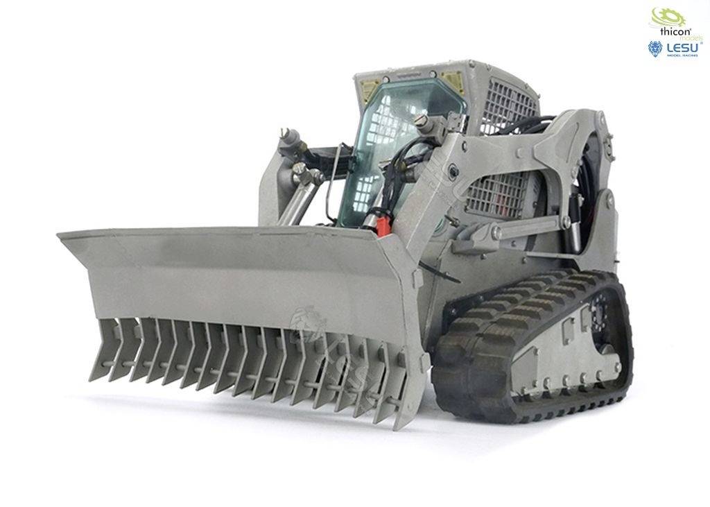 Mały ładowacz łańcuchowy z metalu z nakładką łyżkową, stojący na białym tle.