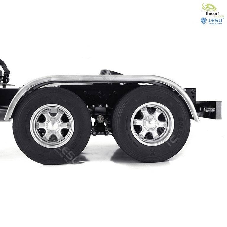 Zbliżenie przyczepy ciężarówki z dwoma dużymi kołami i srebrnymi felgami. W prawym górnym rogu widoczne są logo dwóch producentów.