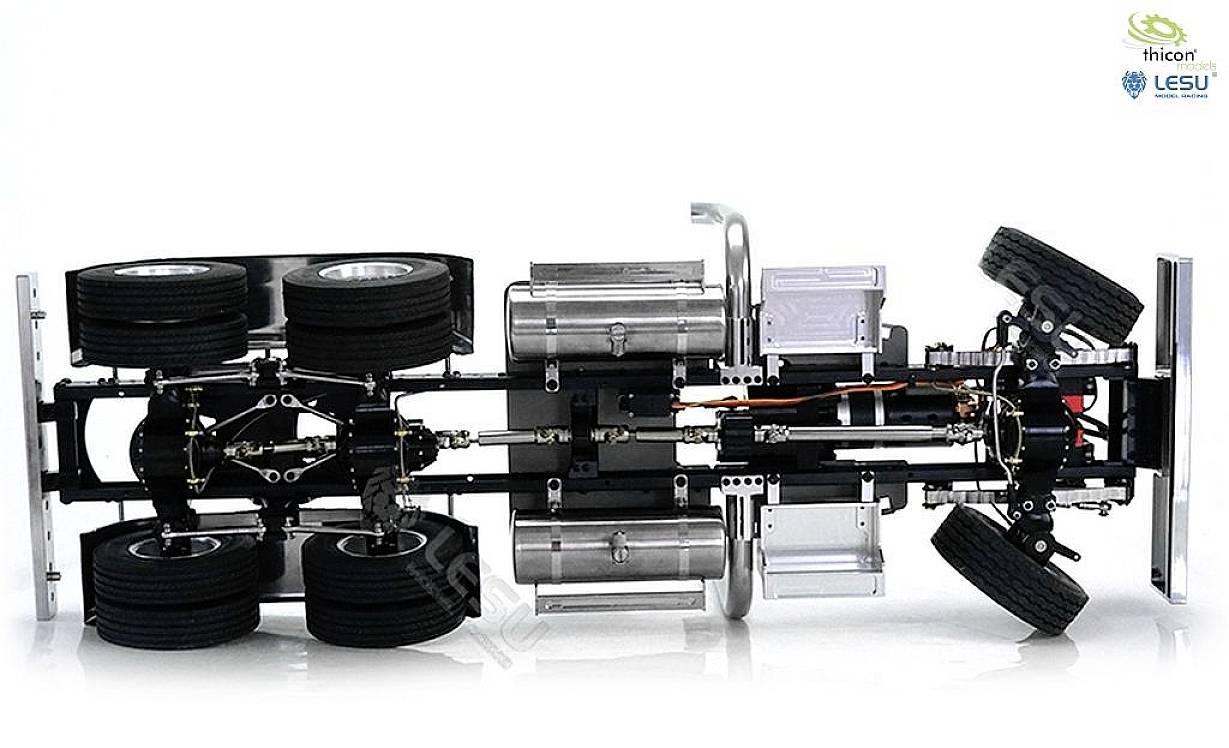 Model podwozia ciężarówki widziany od spodu, z widocznymi komponentami takimi jak koła, osie i zawieszenie. Logotypy marek w prawym górnym rogu.