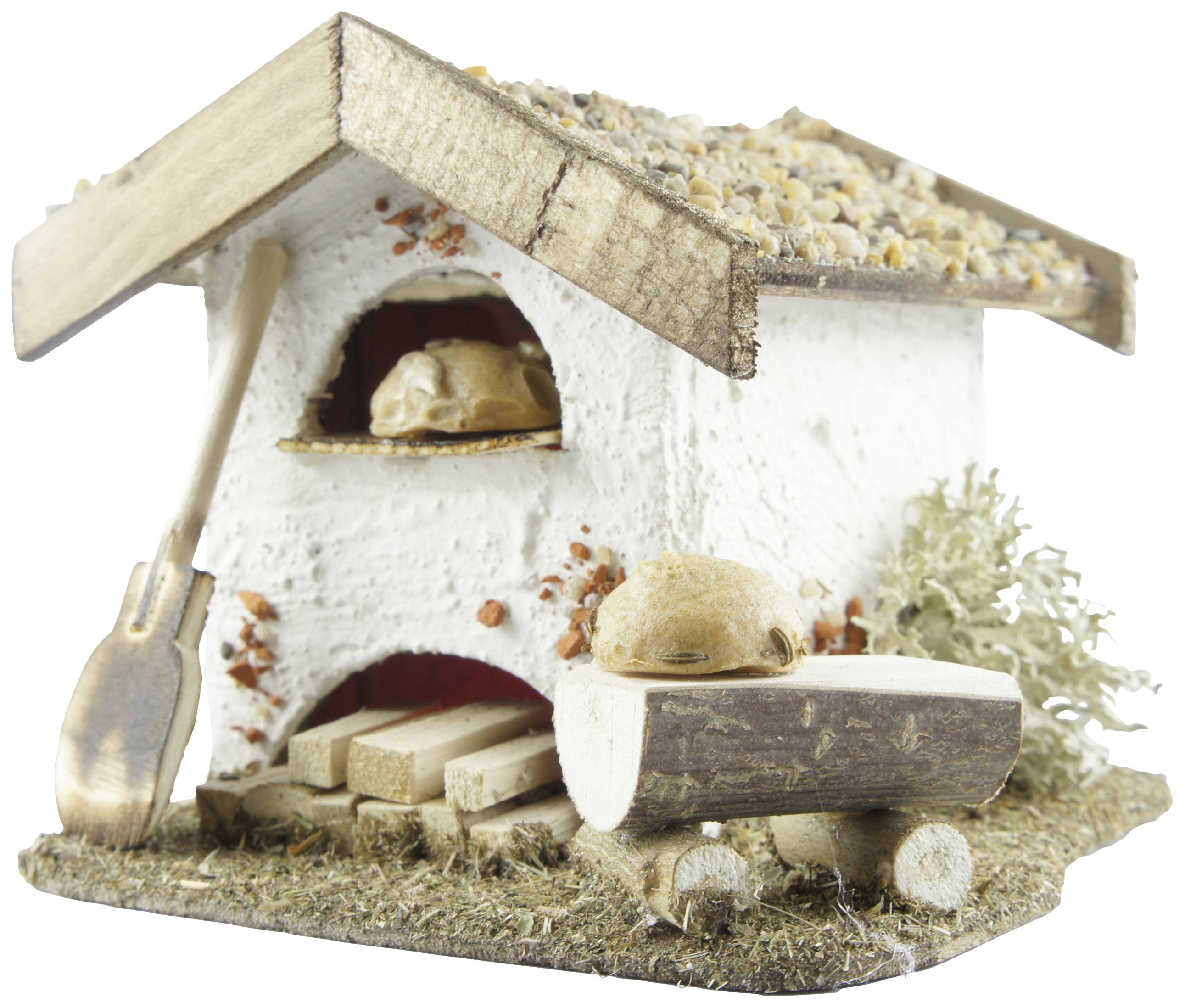 Mały miniaturowy domek z drewna z dachem pokrytym żwirem. Przed domem leży chleb na drewnianym stole z małą łopatką.