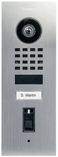 Stalowy domofon z kamerą, głośnikiem i przyciskiem dzwonka. Na tabliczce widnieje nazwisko 'S. Martin'.