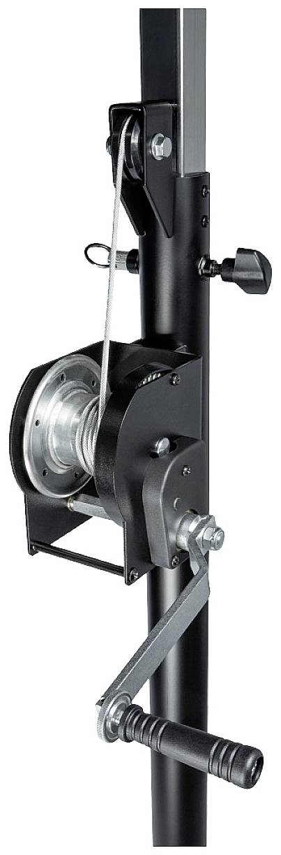 Czarny, metalowy mechanizm linowy z korbą ręczną zamontowany na pionowym statywie; służy do podnoszenia ciężkich ładunków.