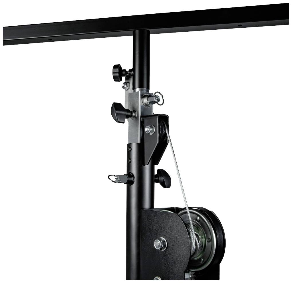 Czarna, pionowa metalowa belka z elementami mechanicznymi i linką, prawdopodobnie będąca częścią mechanizmu podnoszącego lub podtrzymującego.