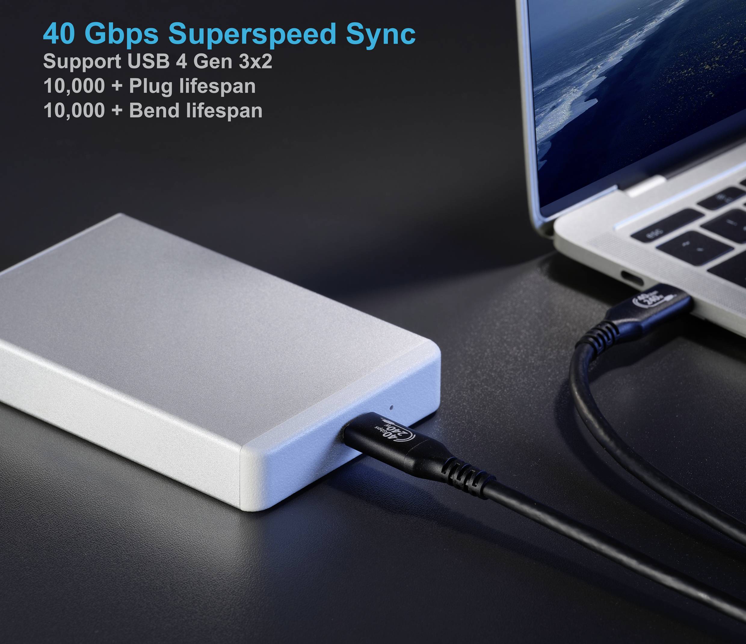 Zewnętrzny srebrny dysk przenośny podłączony kablem USB do laptopa. Tekst wyświetla '40 Gbps Superspeed Sync' oraz inne szczegóły techniczne.