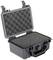 Czarny, twardy kufer z tworzywa sztucznego, otwarty. Pokrywa wyłożona jest pianką zabezpieczającą, która zapewnia bezpieczne przechowywanie przedmiotów.
