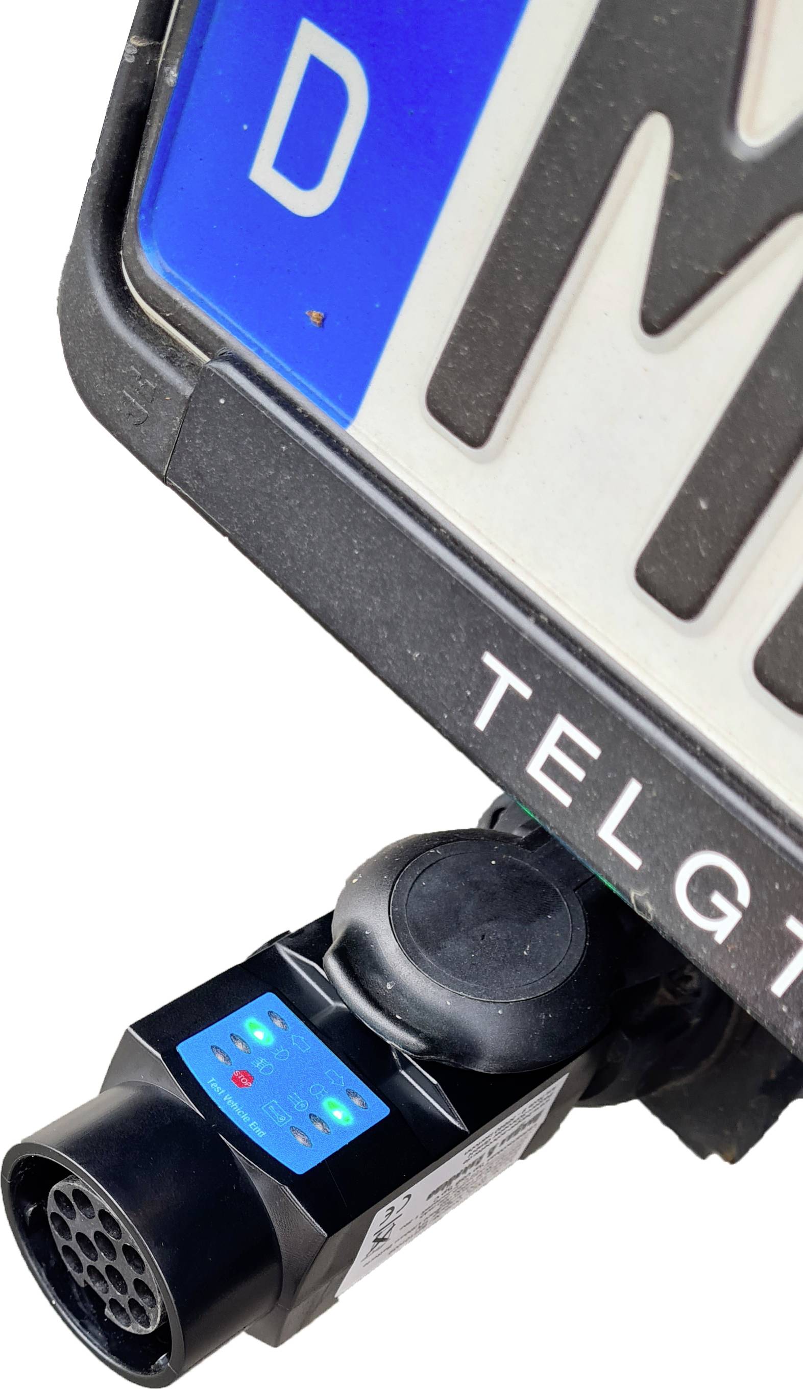 Niemiecka tablica rejestracyjna z niebieską naklejką UE na białym tle. Urządzenie elektroniczne jest zamontowane na dolnej części tablicy rejestracyjnej.