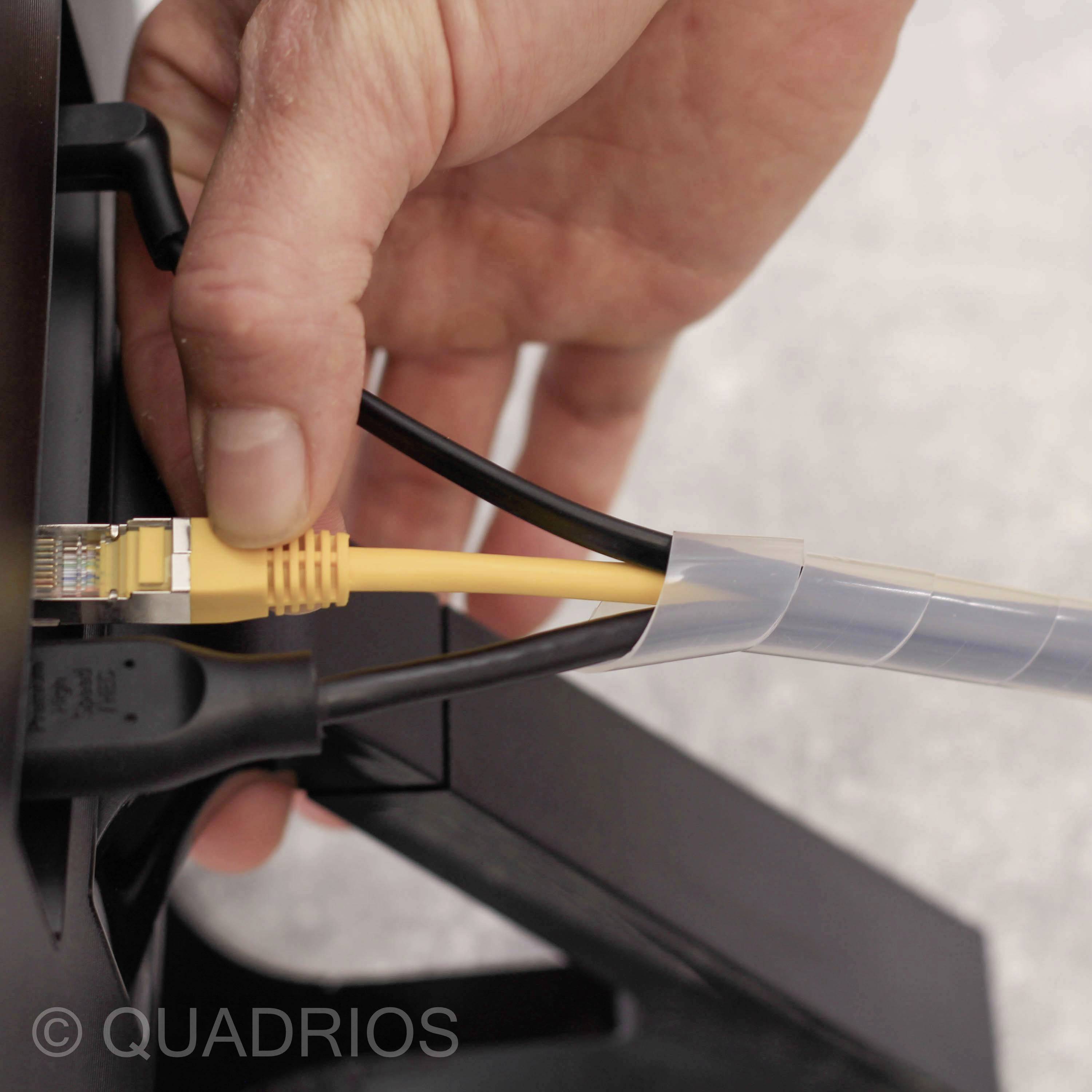 Ręka wkłada żółty kabel Ethernet do gniazda urządzenia. Po lewej stronie podłączony jest czarny kabel.