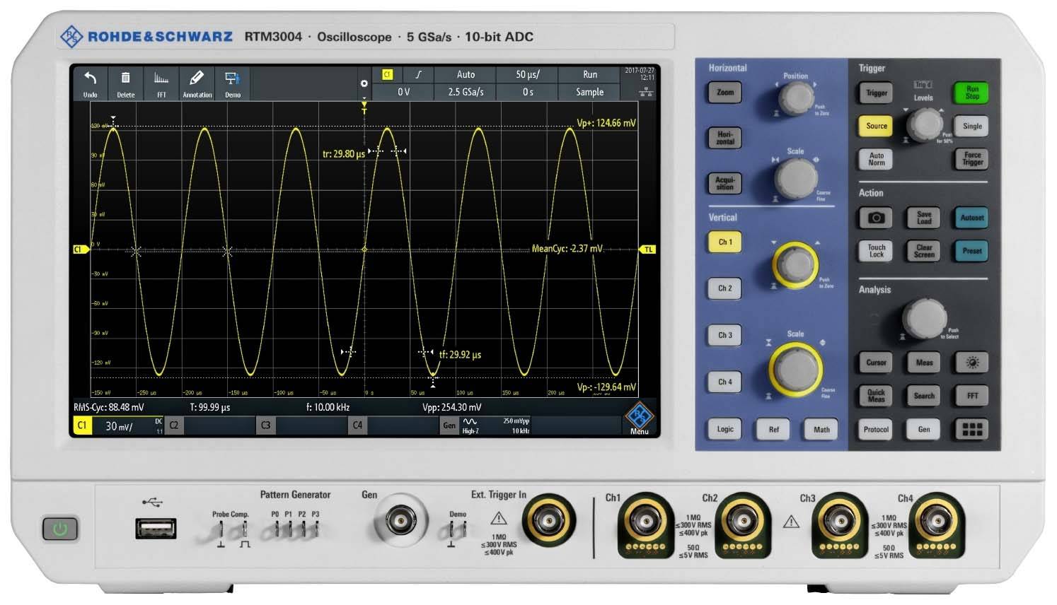 Oscyloskop na stole wyświetla fale sinusoidalne na ekranie. Panel sterowania po prawej stronie z różnymi elementami obsługi i pokrętłami.