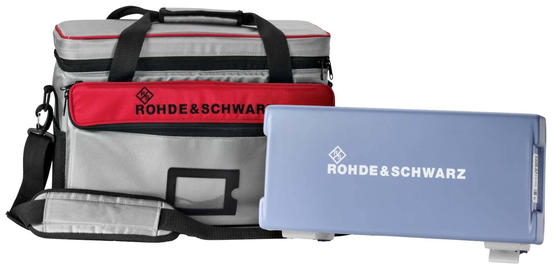 Szara i czerwona torba z napisem 'ROHDE & SCHWARZ', obok niebieskie etui z tym samym logo. Odpowiednia do przewożenia sprzętu technicznego.