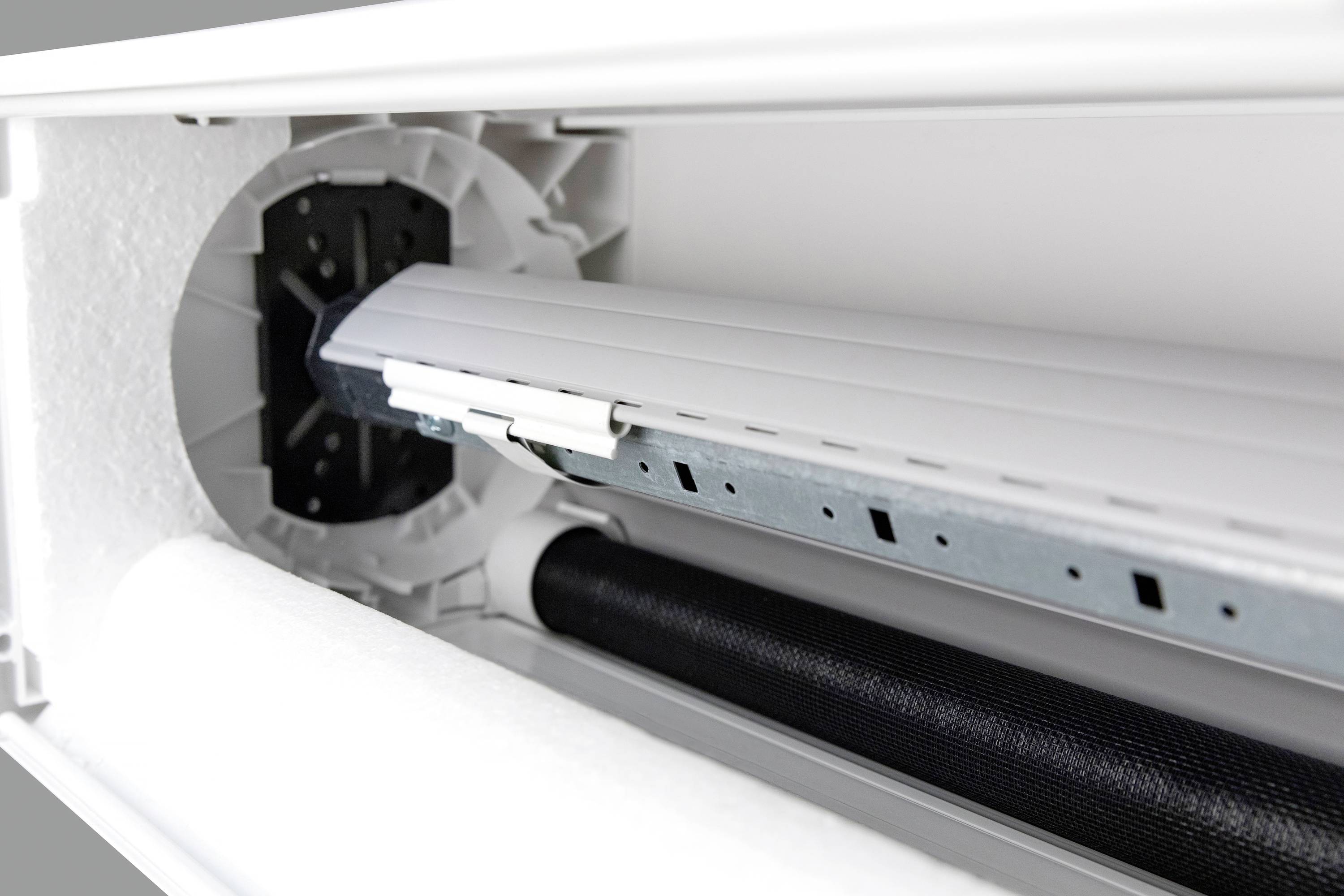 Zbliżenie na skrzynkę rolety z widocznymi szczegółami technicznymi, takimi jak szyny i mechanizm zwijania.