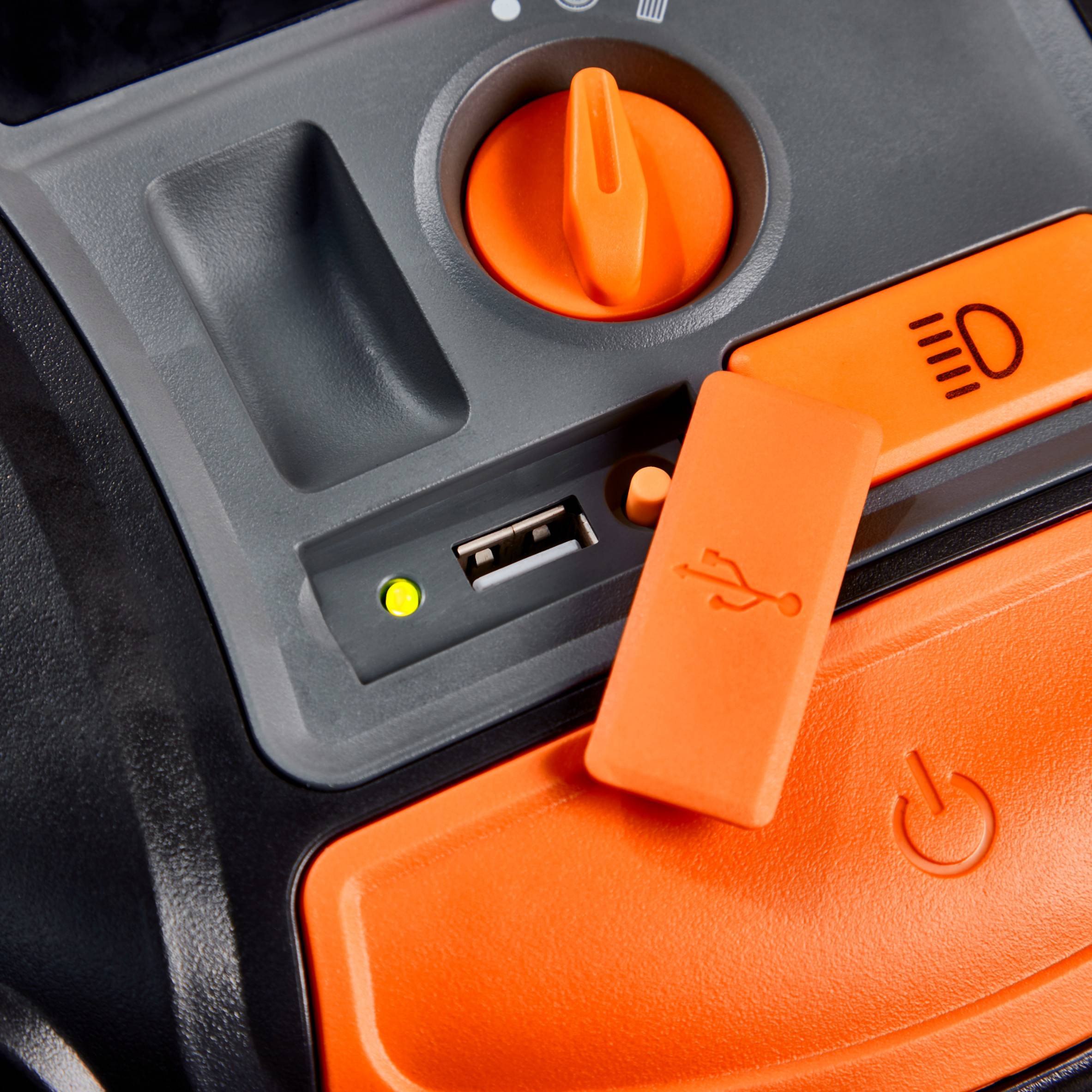 Zbliżenie pomarańczowej listwy zasilającej z przesuwnym regulatorem, gniazdem USB i głównym włącznikiem na urządzeniu.