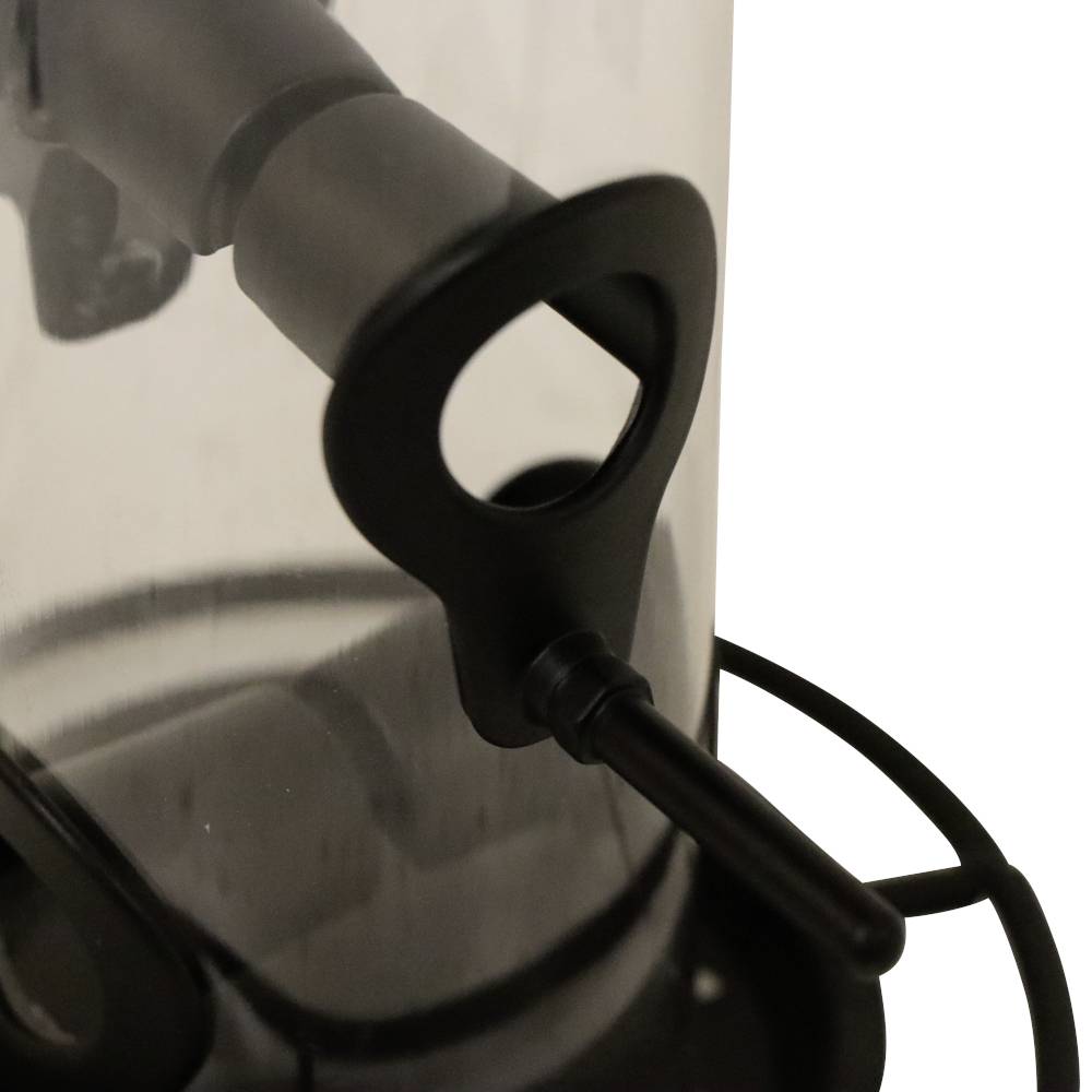 Czarny uchwyt w kształcie klucza wystaje z cylindrycznego, przezroczystego pojemnika. Pojemnik posiada metalowe elementy.