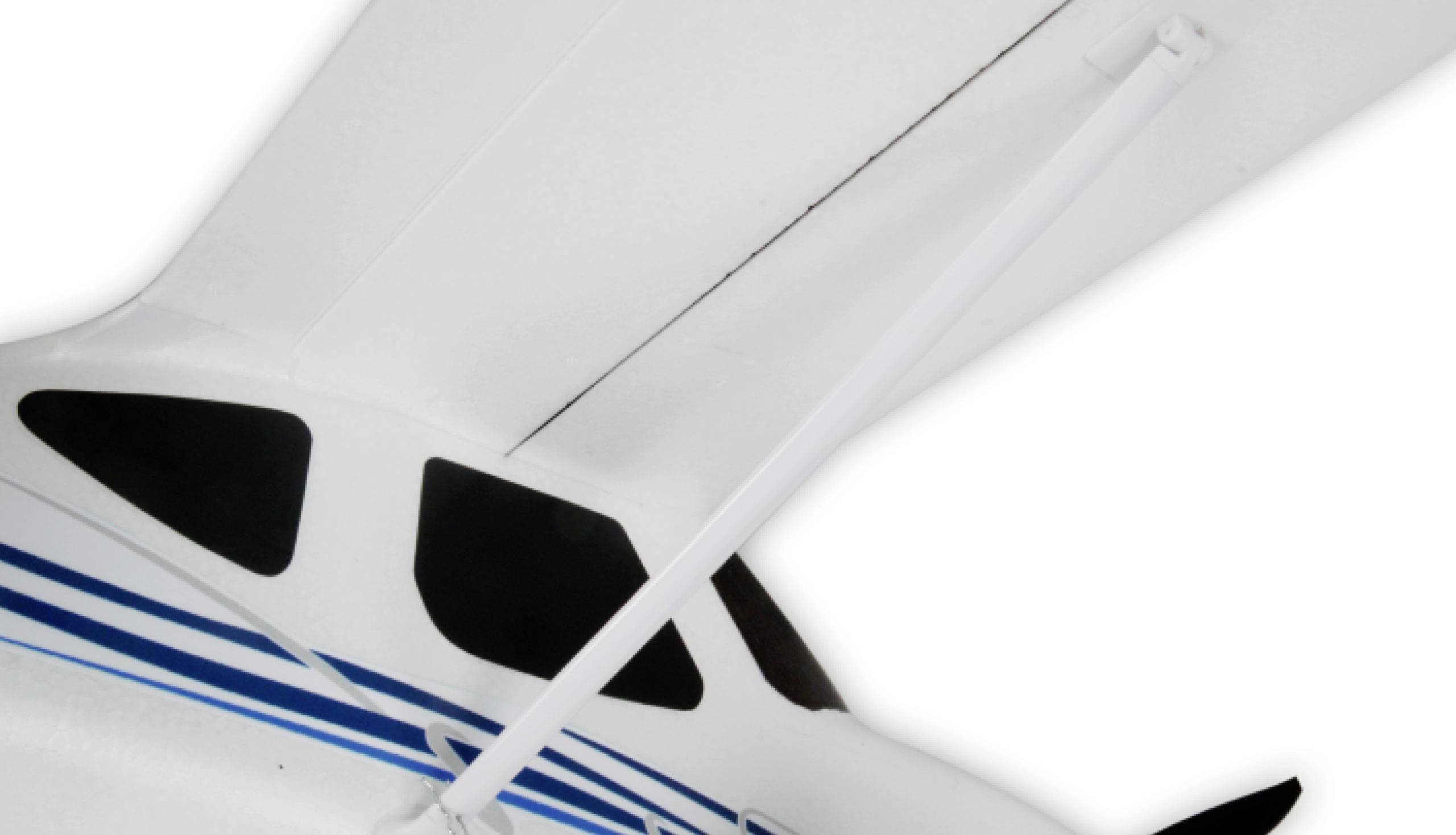 Zbliżenie białego modelu samolotu z niebieskimi paskami i czarnymi oknami, z fokusem na skrzydle i podwoziem.