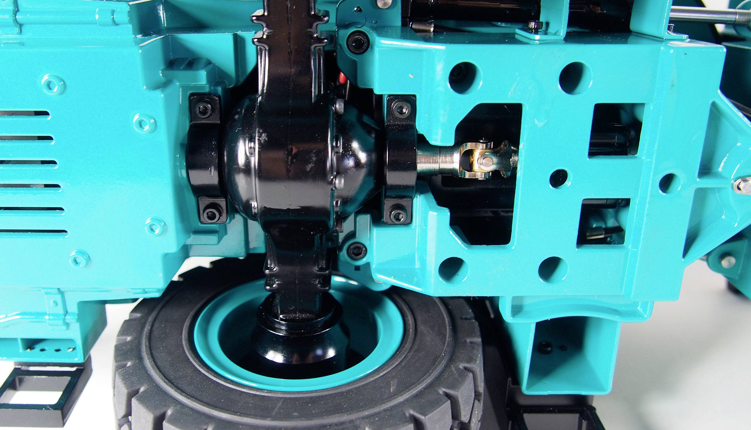 Turkusowy robot lub urządzenie budowlane z widocznym mechanizmem zębatym i czarnym przegubem. Nacisk położony jest na technicznej mechanice.