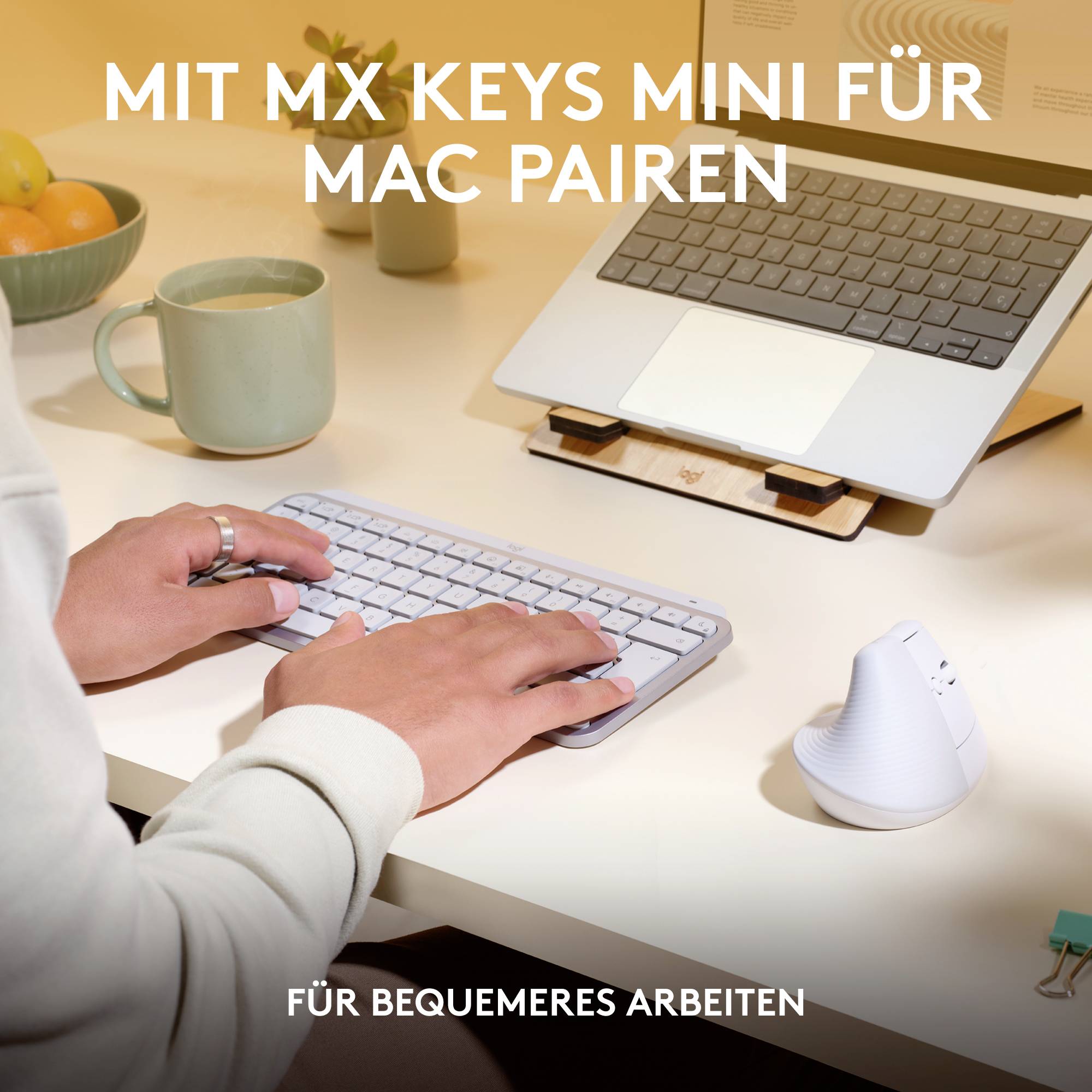 Osoba pracuje przy biurku z klawiaturą MX Keys Mini i laptopem. Tekst: 'MX Keys Mini dla wygodniejszej pracy'.
