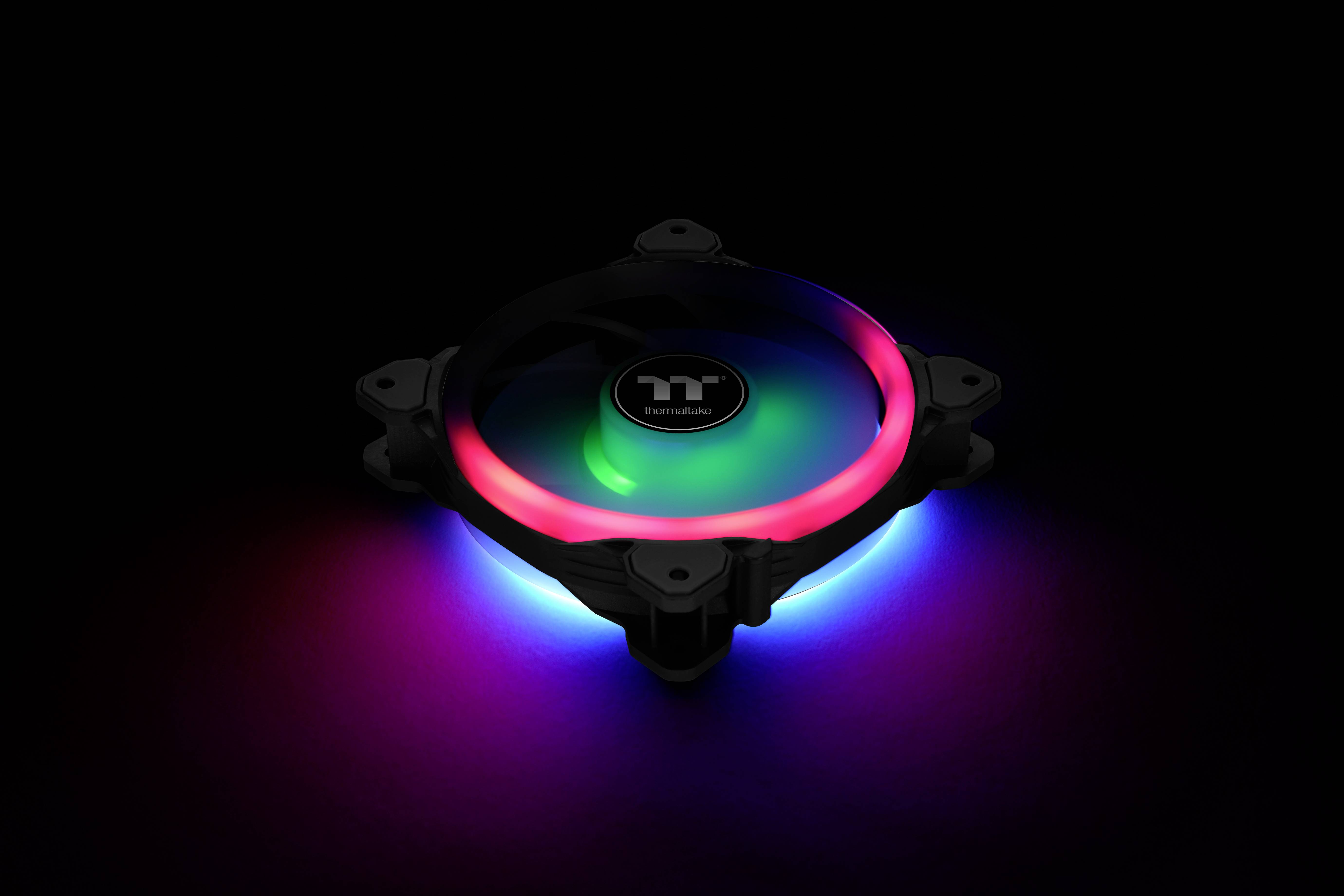 Wentylator obudowy RGB z podświetlonym logo Thermaltake pośrodku. Pierścień świeci na czerwono, zielono i niebiesko w ciemnym otoczeniu.