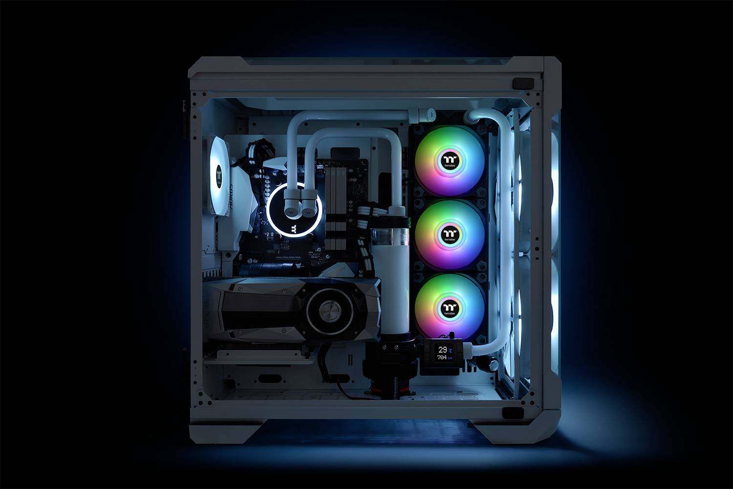 Przezroczysty komputer z kolorowym podświetleniem LED. Widoczne komponenty: karta graficzna, system chłodzenia, trzy kolorowe wentylatory. Ciemne tło.