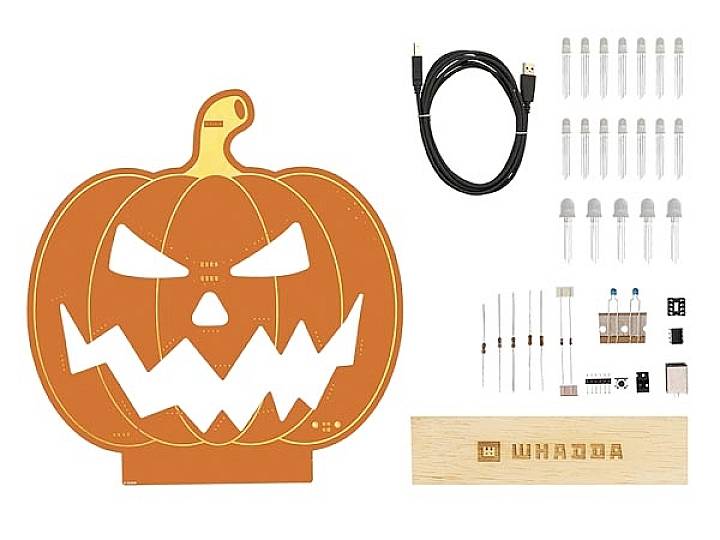 Elektroniczny zestaw do budowy w kształcie dyni z diodami LED, przewodami i komponentami elektronicznymi, gotowy do projektów halloweenowych.