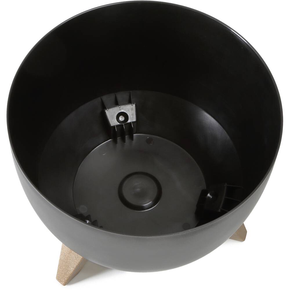 Czarna okrągła misa na trzech drewnianych nogach, używana jako doniczka, o nowoczesnym wzornictwie.