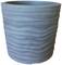 Doniczka z jasnoniebieskiego, falistego tworzywa sztucznego o nowoczesnym, falistym wzornictwie.