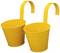 Dwa żółte wiadra metalowe z hakami do zawieszania, przydatne do prac ogrodowych lub jako dekoracja.