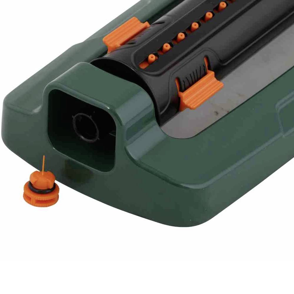 Zielony zraszacz trawnikowy z pomarańczowymi dyszami i czarnym mechanizmem obrotowym, przeznaczony do nawadniania powierzchni ogrodowych.