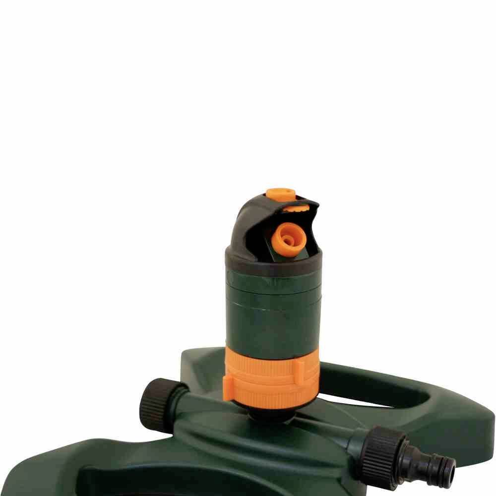 Zielony, automatyczny zraszacz ogrodowy z pomarańczowymi akcentami, umieszczony na płaskiej powierzchni, gotowy do nawadniania.