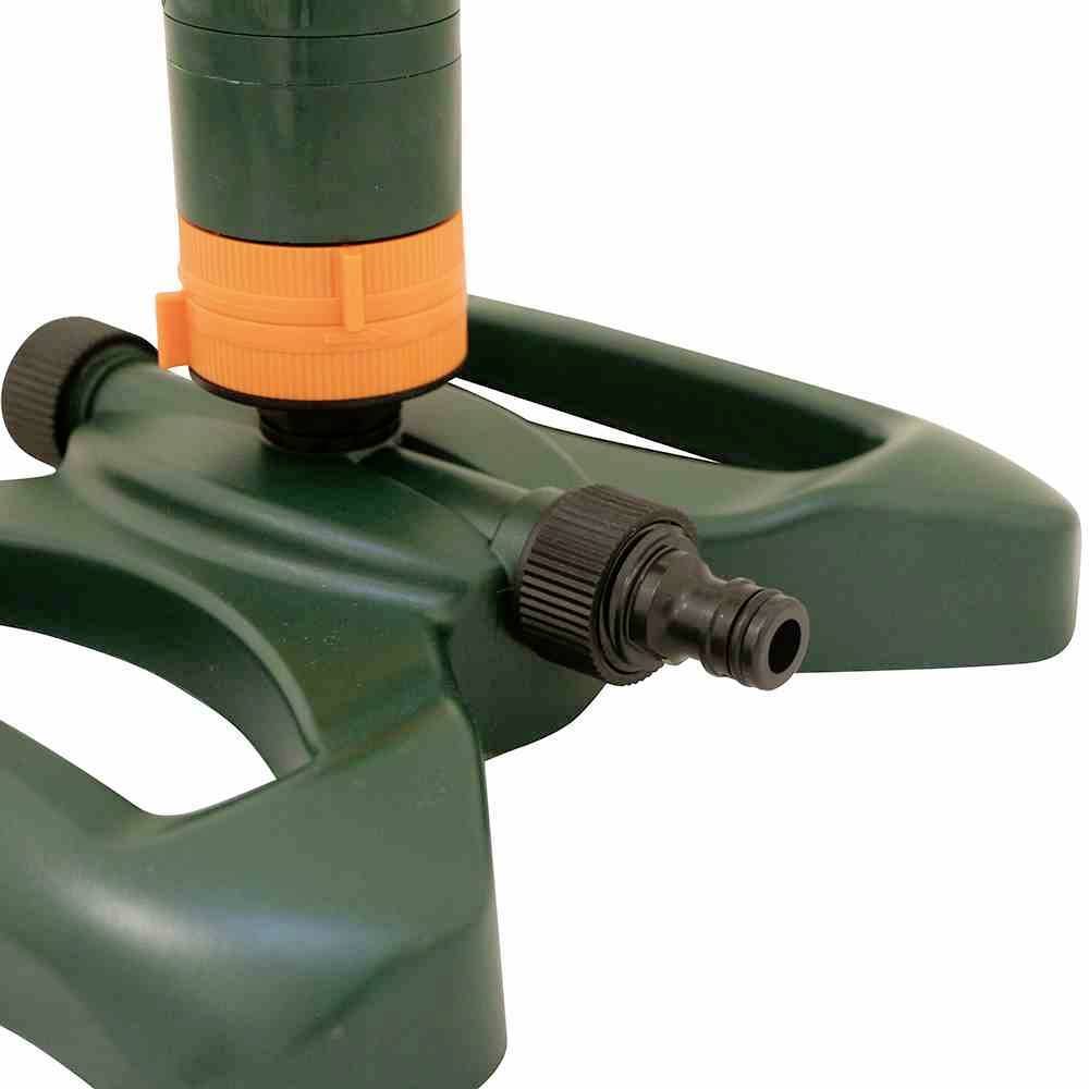 Plastikowy zraszacz ogrodowy w kolorze zielonym z pomarańczowym mechanizmem obrotowym stoi na stabilnej podstawie. Odpowiedni do równomiernego nawadniania.