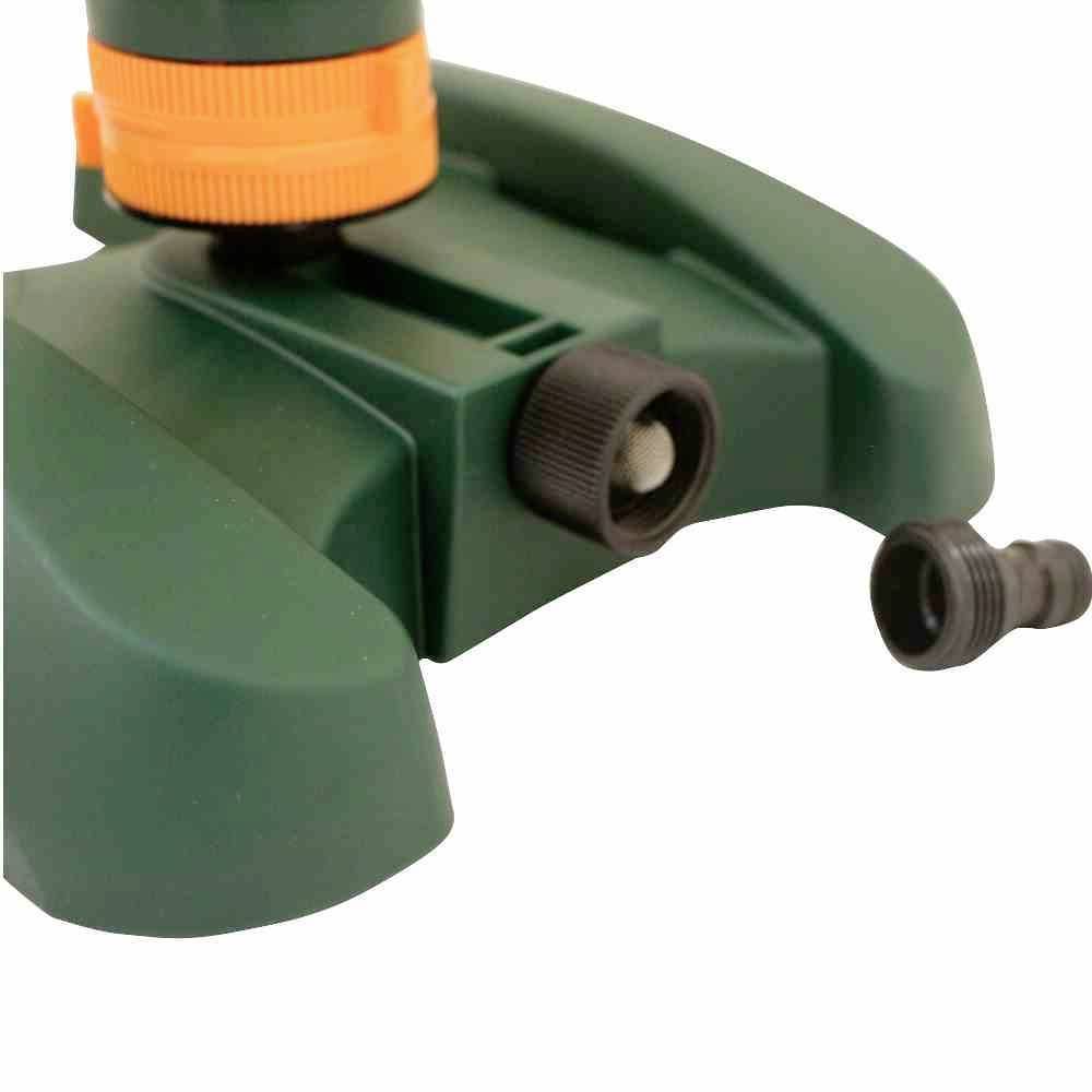 Zbliżenie zielonego zraszacza ogrodowego z czarnym złączem i pomarańczowym mechanizmem obrotowym na stabilnej podstawie.