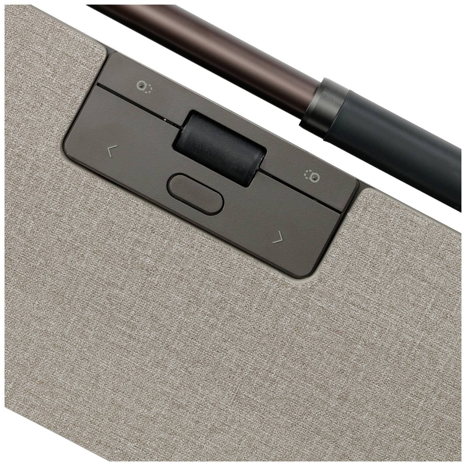 Klawiatura laptopa z brązową tkaniną oraz czarnym touchpadem. Pióro w kolorze miedzi leży na niej ukośnie.