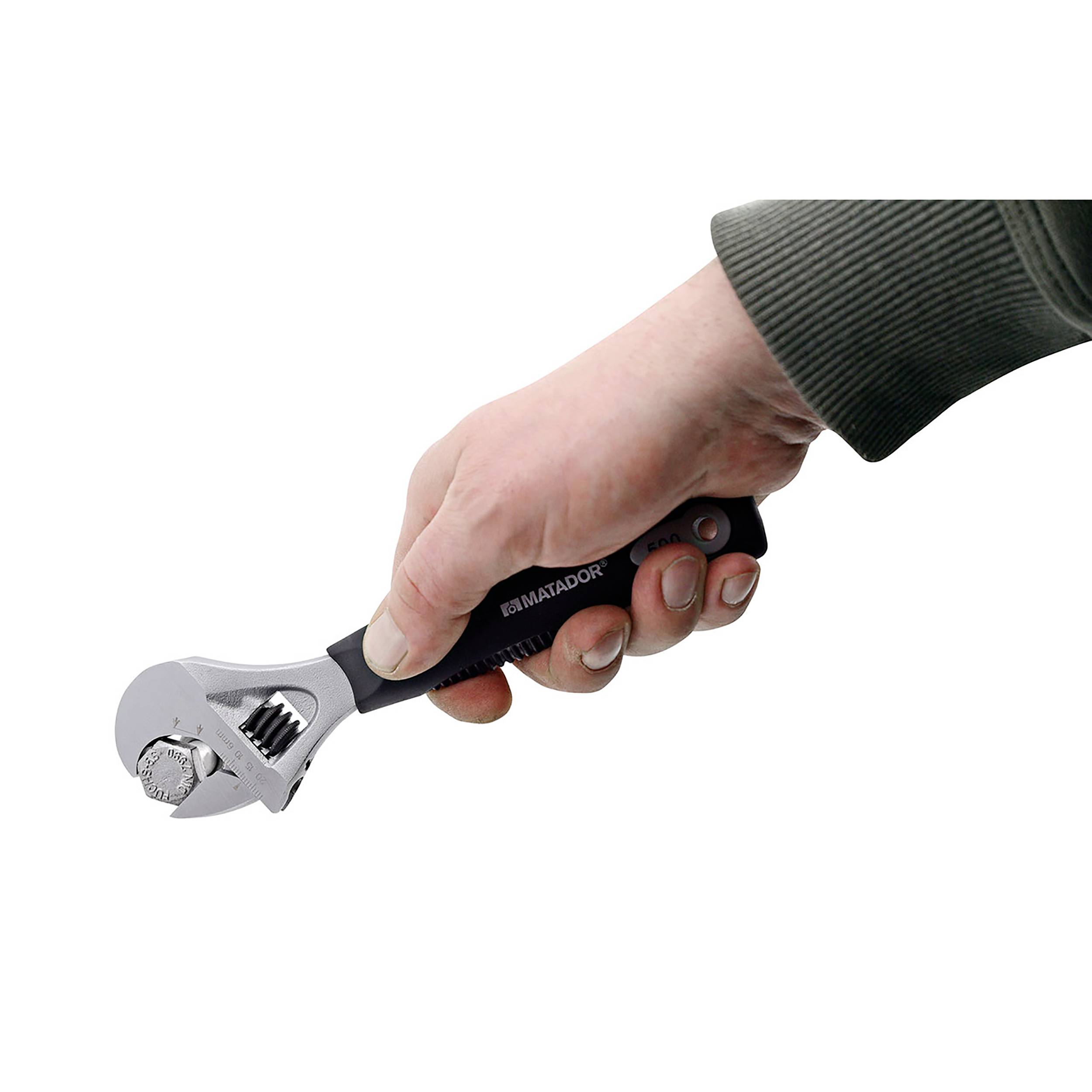 Dłoń trzyma regulowany klucz nastawny, używany do dokręcania lub poluzowywania nakrętek i śrub.